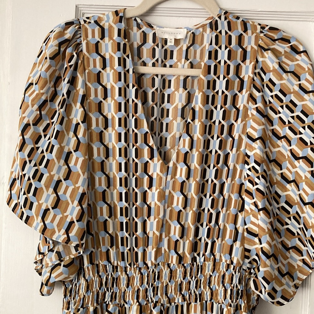 Geometric print dress in brown, beige, and blue with handkerchief hem